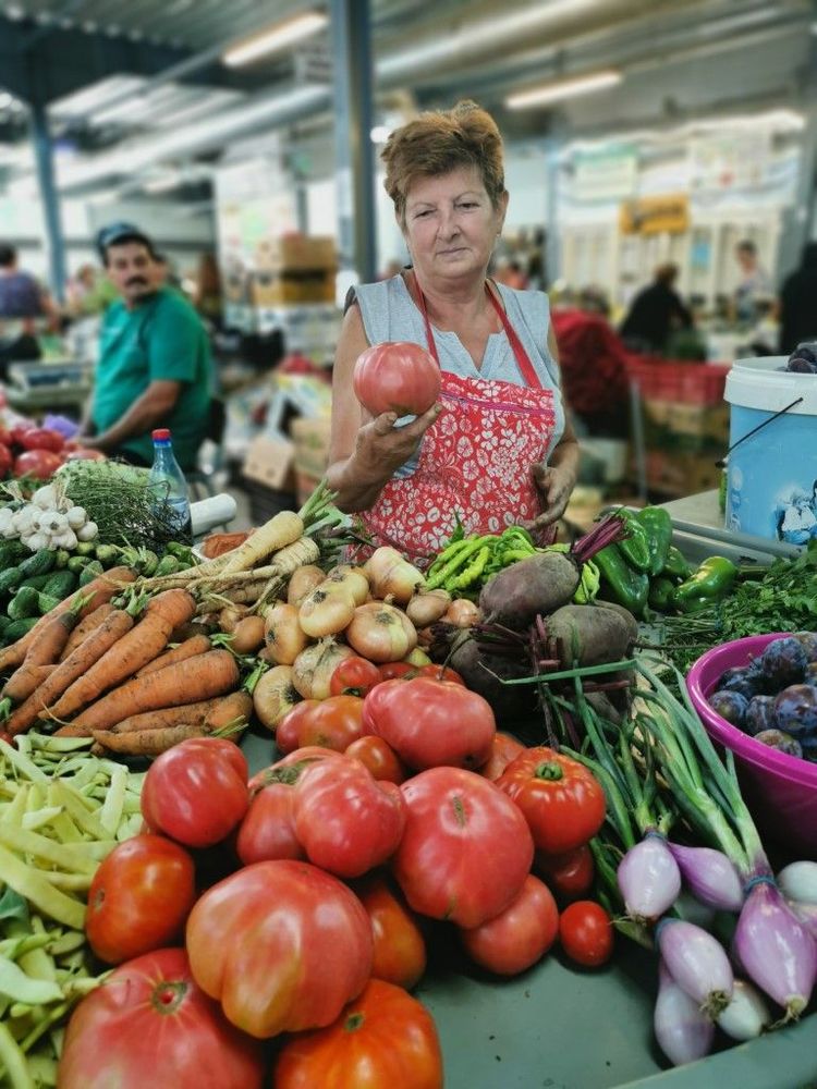 Large market with lush vegetable stalls.